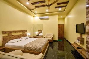 um quarto com uma cama e uma televisão de ecrã plano em hotel saptarang residency panhala em Panhāla