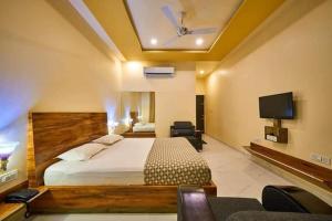 a bedroom with a bed and a flat screen tv at hotel saptarang residency panhala in Panhāla