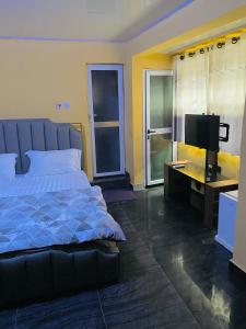 a bedroom with a bed and a flat screen tv at Jennabwa Lodge and Restaurant in Freetown