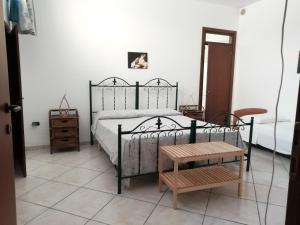 um quarto com uma cama preta e uma mesa de madeira em Residenza Del Sole em Surbo