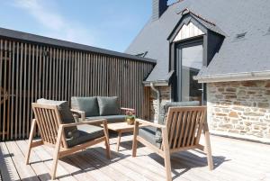 2 sillas y una mesa en una terraza de madera en Villa Jacqueline, en Dragey