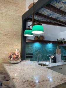 una cocina con 2 luces verdes sobre un mostrador en Casa Sierraverde Fuenteheridos by MSHOLIDAYS, en Fuenteheridos