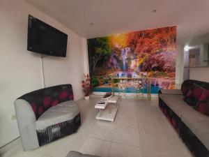 a living room with a large painting on the wall at Apartamento en Buga a 7min de la Básilica in Buga
