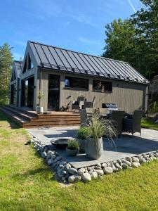une petite maison avec une terrasse et un patio dans l'établissement Perle ved sjøen! Ny hytte på 90m2., à Kragerø