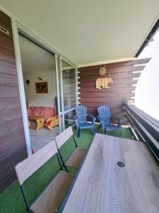 - une terrasse couverte avec 2 chaises et une table en bois dans l'établissement Appartement Montagnard Serre-Chevalier., à Saint-Chaffrey