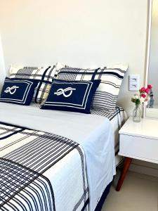Lençóis Confort 201 في باريرينهاس: غرفة نوم مع سرير ووسائد زرقاء وبيضاء