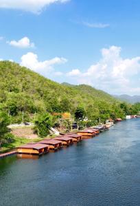 a river with a bunch of boats in the water at ธารามนตรา รีสอร์ท (Taramontra resort) in Tha Kradan