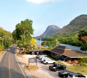 a street with cars parked in front of a building at ธารามนตรา รีสอร์ท (Taramontra resort) in Tha Kradan