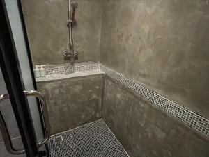 een badkamer met een douche en een tegelvloer bij ธารามนตรา รีสอร์ท (Taramontra resort) in Tha Kradan
