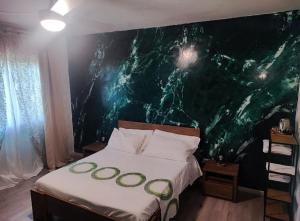a bedroom with a bed with a green wall at Relais Delta Bed Breakfast 