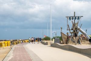 people walking along a boardwalk on the beach at Ferienwohnung Heimathafen in Cuxhaven