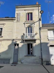 een wit gebouw met een balkon en een deur bij Cosy Flat vue château Loire à velo in Saumur
