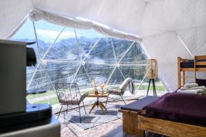a room with a bed and chairs in a tent at Alpenlodges in Braunwald