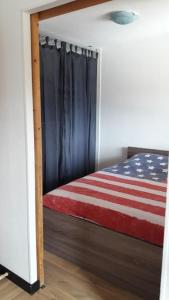 a room with a bed with an american flag on it at APPARTEMENT PIEDS DE PISTE - 4-6 PERSONNES in La Chal