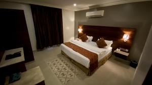 een slaapkamer met een bed in een hotelkamer bij البستان للأجنحة الفندقية in Al Hofuf