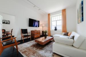 ein Wohnzimmer mit einem weißen Sofa und einem Tisch in der Unterkunft First Wohnen in Osterode