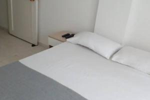 1 Schlafzimmer mit 2 weißen Betten und einem Tisch in der Unterkunft @casa_grace Bienvenidos! in Cartagena de Indias