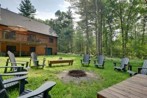 un groupe de chaises et un foyer extérieur en face d'une cabane en rondins dans l'établissement Cozy Arkdale Wood Cabin Near Petenwell Lake!, à New Rome