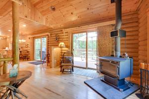 - un salon avec un poêle à bois dans une cabane en rondins dans l'établissement Cozy Arkdale Wood Cabin Near Petenwell Lake!, à New Rome