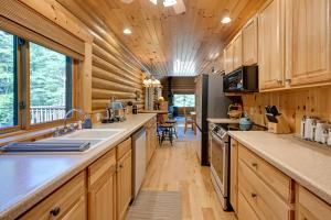 une cuisine avec des armoires en bois et un grand comptoir dans l'établissement Cozy Arkdale Wood Cabin Near Petenwell Lake!, à New Rome