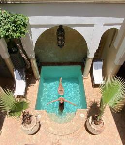 una persona nadando en una piscina en una casa en Riad des Fragrances dar el Bacha en Marrakech