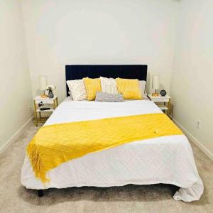 a bedroom with a large bed with a yellow blanket at Cozy 1 Bedroom Basement Apt in SE Calgary in Calgary