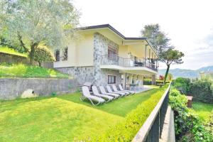 サン・フェリーチェ・デル・ベナーコにあるLake View Garda Villa Salò Gulfの芝生の上に椅子が並ぶ家