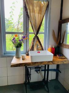 um lavatório de casa de banho numa mesa de madeira com uma janela em Romantic house 2 on a pine hill Dalat em Da Lat