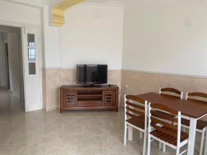 a dining room with a table and a television on a cabinet at BOUS in Tichi