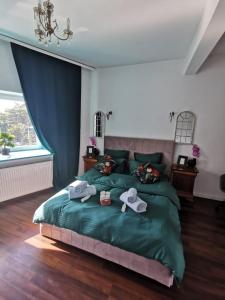 ein Schlafzimmer mit einem grünen Bett und Handtüchern darauf in der Unterkunft WOW INN COTROCENI in Bukarest