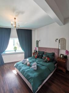 ein Schlafzimmer mit einem Bett mit einer grünen Bettdecke in der Unterkunft WOW INN COTROCENI in Bukarest