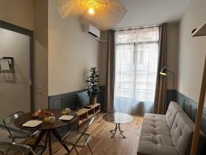 a living room with a table and a couch at Cours République in Narbonne