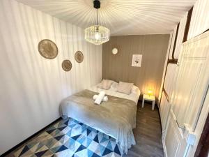una camera con letto e lampadario a braccio di Au nid des remparts à Eguisheim a Eguisheim