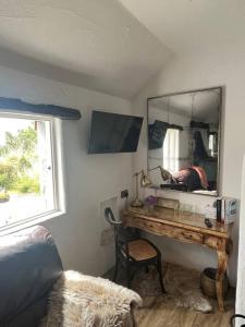 um quarto com uma secretária com um espelho e uma cadeira em The Nest Quaint Luxury Cottage Getaway em Tiragarvan