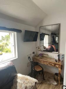 a bedroom with a desk with a mirror and a chair at The Nest Quaint Luxury Cottage Getaway in Tiragarvan