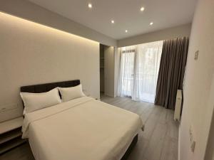 sypialnia z białym łóżkiem i dużym oknem w obiekcie GSS - 5 Apartment w mieście Tbilisi City