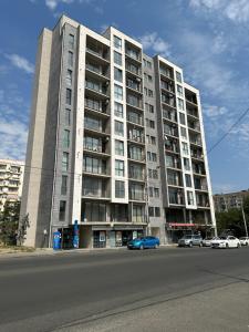 duży budynek z zaparkowanymi przed nim samochodami w obiekcie GSS - 5 Apartment w mieście Tbilisi City