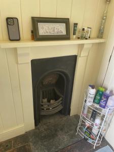 a fireplace in a room with a shelf above it at Westbrook-Homestay in Swansea