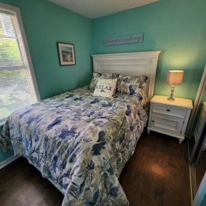 a bedroom with a bed and a lamp on a night stand at 18Th Street - Galveston Seawall Close to Attractions! Remodeled! in Galveston