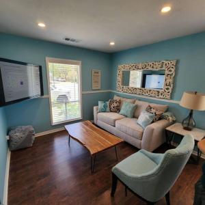 a living room with a couch and a table at 18Th Street - Galveston Seawall Close to Attractions! Remodeled! in Galveston