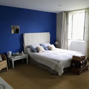 a blue bedroom with a large bed and a window at Au Fil de Soi in Vézénobres