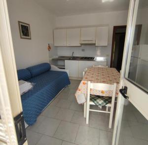 ポルトフェッラーイオにあるResidence Alithaiのベッド、テーブル、キッチンが備わる客室です。
