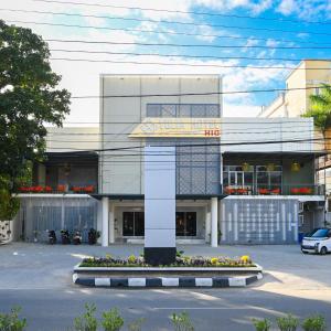 un edificio con una torre dell'orologio in un parcheggio di Yulia Hotel Managed by HIG a Gorontalo