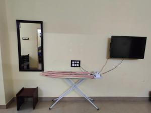 stół z lustrem i telewizor na ścianie w obiekcie The Delux Cabin w mieście Karaikudi