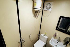a small bathroom with a toilet and a sink at Cozy Cabin very close to Beach in Visakhapatnam