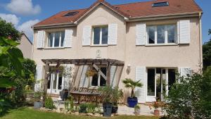 a house with white shutters on the windows at Chez Laurence & RV in Vauréal