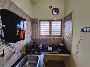 una piccola cucina con lavandino e finestra di The Delux Cabin a Karaikkudi