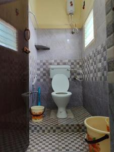 małą łazienkę z toaletą i umywalką w obiekcie The Delux Cabin w mieście Karaikudi