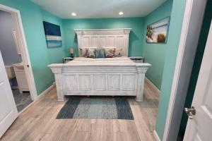 1 dormitorio con 1 cama blanca y paredes azules en Acapulco - Upstairs Beachview Beauty 50 steps to a private beach! BYOT en Galveston