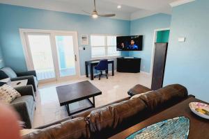 a living room with a couch and a table at Acapulco - Upstairs Beachview Beauty 50 steps to a private beach! BYOT in Galveston